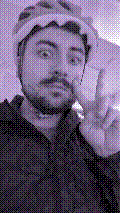 a selfie of a white person, wearing either headphones or a helmet, making an odd expression. the photo is edited to be colorized into a monochrome purple-ish color palette.