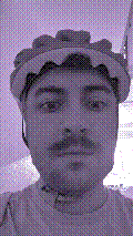 a selfie of a white person, wearing either headphones or a helmet, making an odd expression. the photo is edited to be colorized into a monochrome purple-ish color palette.