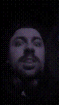 a selfie of a white person, wearing either headphones or a helmet, making an odd expression. the photo is edited to be colorized into a monochrome purple-ish color palette.