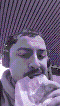 a selfie of a white person, wearing either headphones or a helmet, making an odd expression. the photo is edited to be colorized into a monochrome purple-ish color palette.